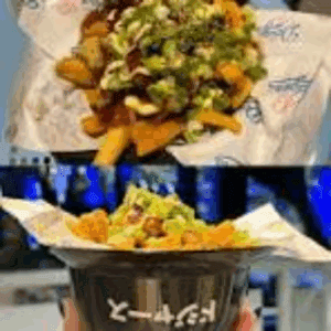 Loaded fries with toppings in a bowl.